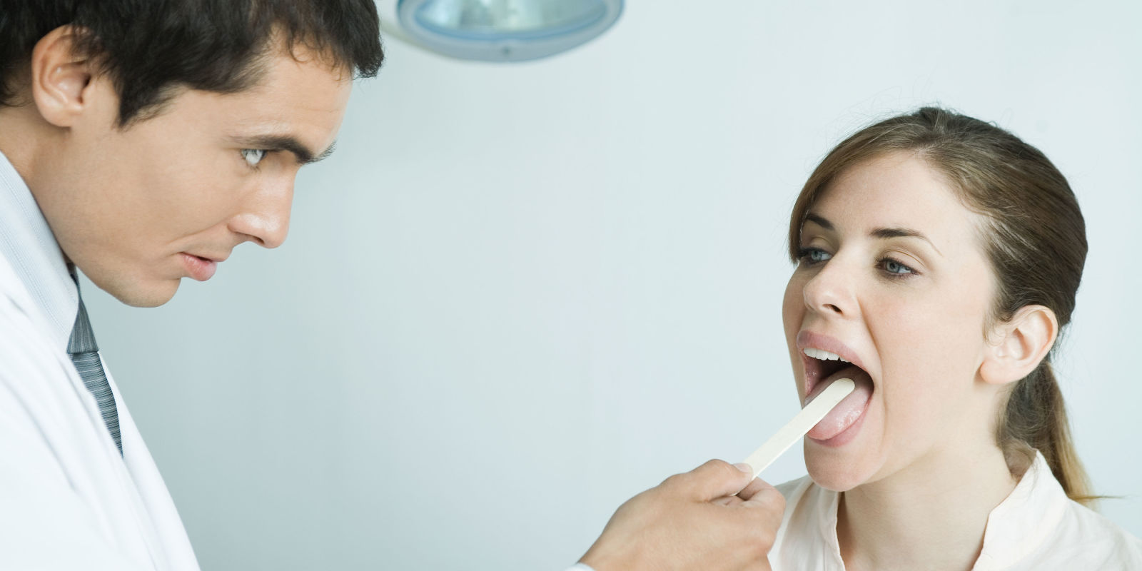 Солоно во рту причины у мужчин. Врач осматривает рот. Профилактика кандидоза слизистой оболочки рта.